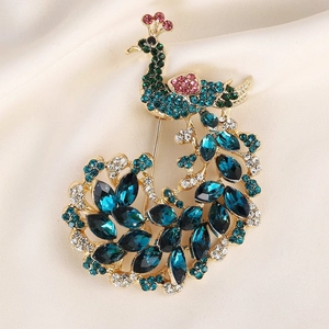 Elegant peacock brooch with colorful rhinestones on silk background for fashion accessories