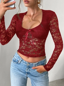 Détail du haut en dentelle rouge foncé avec décolleté en U et nœud papillon décoratif