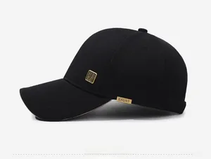 Close-up of side profile on black baseball cap with gold metal badge and sport tag