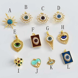 Collection of 12 gold-plated evil eye charms in sunburst, heart, and geometric shapes