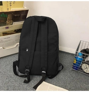 Rear view of a black minimalist large capacity backpack in a lifestyle setting