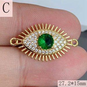Detailed macro of a 27.2x15mm golden evil eye pendant connector with green zircon stone