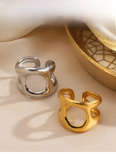 Detailed view of hollow geometric open rings in gold and silver on silk background