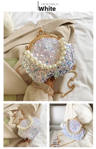 Detail of white sequin shell evening bag with pearl handle and gold chain strap