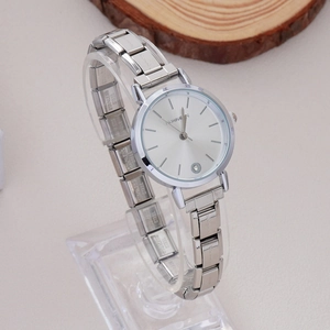Close-up of a silver stainless steel watch with rhinestone details and a round dial