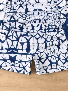 Detailed close-up of blue star geometric print and shirred waist on swimwear fabric