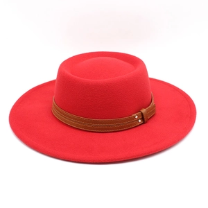Detail of red wool fedora hat featuring brown leather strap and metal buckle accents
