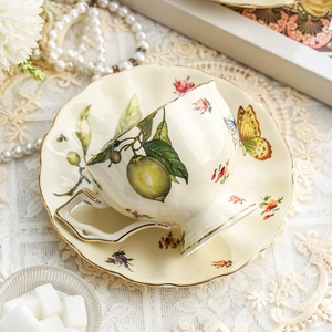 Vintage ceramic coffee cup and saucer set with lemon and floral pattern with gold rim