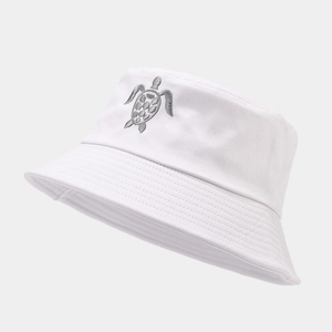Gros plan sur la broderie tortue grise d'un chapeau bob en toile de coton blanc
