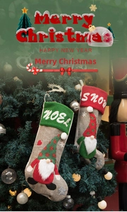 Detail of hanging Christmas stockings with Noel and Snow embroidery on a festive tree