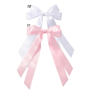 Detailed view of white and pink satin long tail ribbon bow hair clips with silky texture
