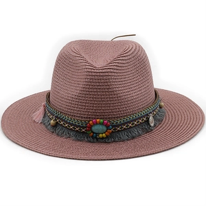 Detail of pink straw sun hat with bohemian beadwork, turquoise stone, and tassel decoration