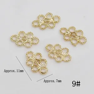 Detailed view of five golden infinity knot alloy charms for DIY jewelry making