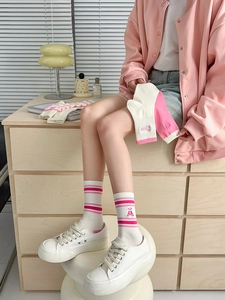 Close-up of pink striped cotton socks featuring cute bear embroidery and ribbed cuffs