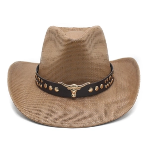 Detail of a brown woven cowboy hat featuring a leather band with gold bull head emblem