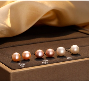 Three pairs of natural freshwater pearl earrings in pink, purple, and white on silk