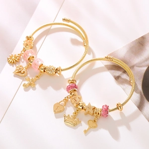 Verstellbare goldene Charm-Armbänder mit rosa Perlen und Herzanhängern auf weißem Grund