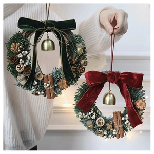 Detail of Christmas pine wreath with velvet bows, gold bells, and dried orange slices