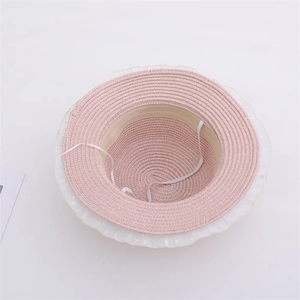 Detailed view of pink straw hat featuring soft lace trim and elastic chin strap for kids