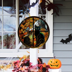 Halloween suncatcher with black cats and autumn leaves hanging on a window