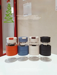 Detail of four colorful glass cups with embossed leather sleeves and safety locks