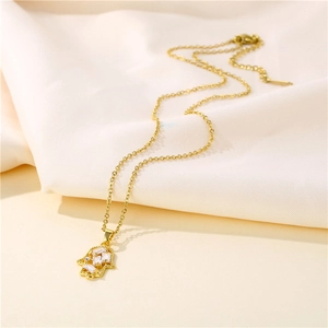 Hamsa Hand Goldkette mit Zirkonia-Anhänger auf elegantem weißem Satin-Hintergrund