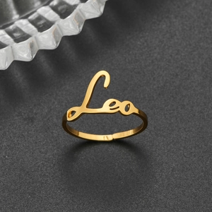 Detail of 18K gold stainless steel ring featuring Leo zodiac lettering and open design