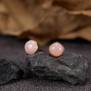 Macro shot of S925 silver stud earrings with pink gemstone on dark stone background