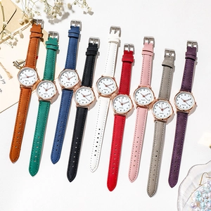 Flat lay of multiple minimalist luminous quartz watches in various vibrant strap colors