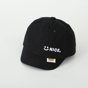 Detailansicht der schwarzen Baumwollkappe mit weißer NICE-Stickerei und Smiley-Symbol