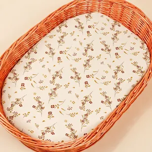 Detailed texture of cotton fitted sheet with vintage floral print for oval baby cradles