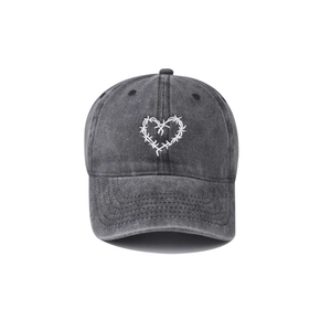 Détail de la broderie cœur d'épines blanche sur la casquette en coton gris délavé