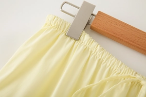 Detailed view of elastic waistband and drawstring on a yellow tiered cotton maxi skirt