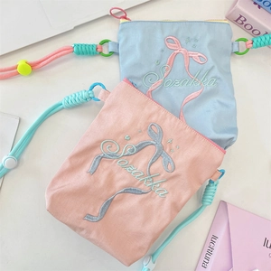 Flachbild von rosa und blauen Nylon-Umhängetaschen mit Schleifenstickerei und Seilgurten