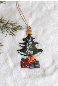 Detail of vintage metal Christmas tree ornament with Welcome text on faux snow background