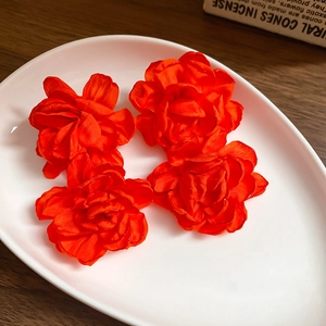 Macro detail of vibrant orange fabric rose pendants for elegant Chinese style earrings