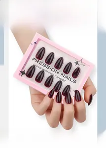 Gros plan d'ongles press-on bordeaux brillants en amande dans leur emballage