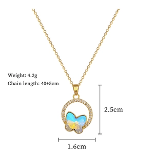 Close-up of golden butterfly pendant with iridescent wings and sparkling crystals on chain