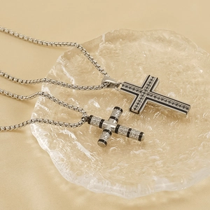 Set aus Titanstahl-Kreuzanhänger-Halsketten in Silber und Schwarz auf einem Tablett