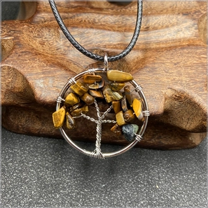 Macro view of silver wire Tree of Life pendant with Tiger Eye stones on wood base