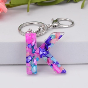 Colorful resin letter K keychain with pink blue shell flakes and silver metal clasp