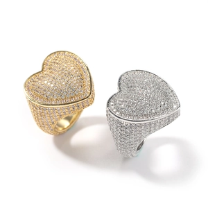Detailed view of gold and silver hip hop rings with heart shaped micro pavé zircon settings