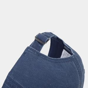 Close-up of the adjustable metal buckle and cotton texture on the back of the blue baseball cap