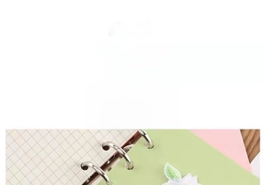 Detail of white flower embroidery patch with self-adhesive backing on a green notebook
