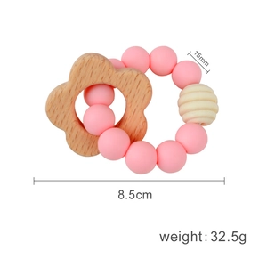 Pink silicone and beech wood flower baby teether ring with dimensions and weight specs