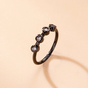 Detailed close-up of a black plated nose ring featuring four micro-paved zircons on beige