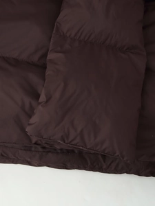 Close-up of quilted coffee brown nylon fabric with soft padded texture for winter jacket