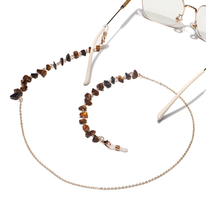 Detail of gold chain glasses strap with natural tiger eye stone beads and silicone loops