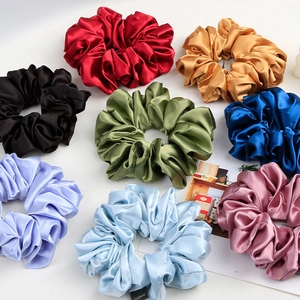 Detail of colorful oversized satin scrunchies with elegant glossy texture and pleated design