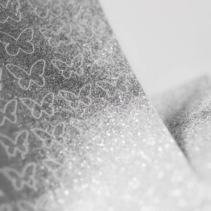 Makroaufnahme von silbernen Glitzer-Schmetterlings-Nagelstickern mit feiner Textur